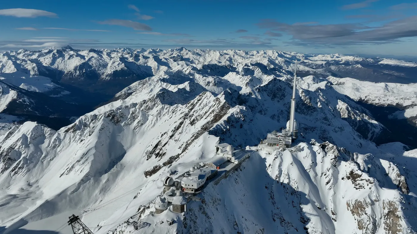 Le Pic du Midi de Bigorre enneigé vu du ciel, l'observatoire sur la crête et les Pyrénées à perte de vue